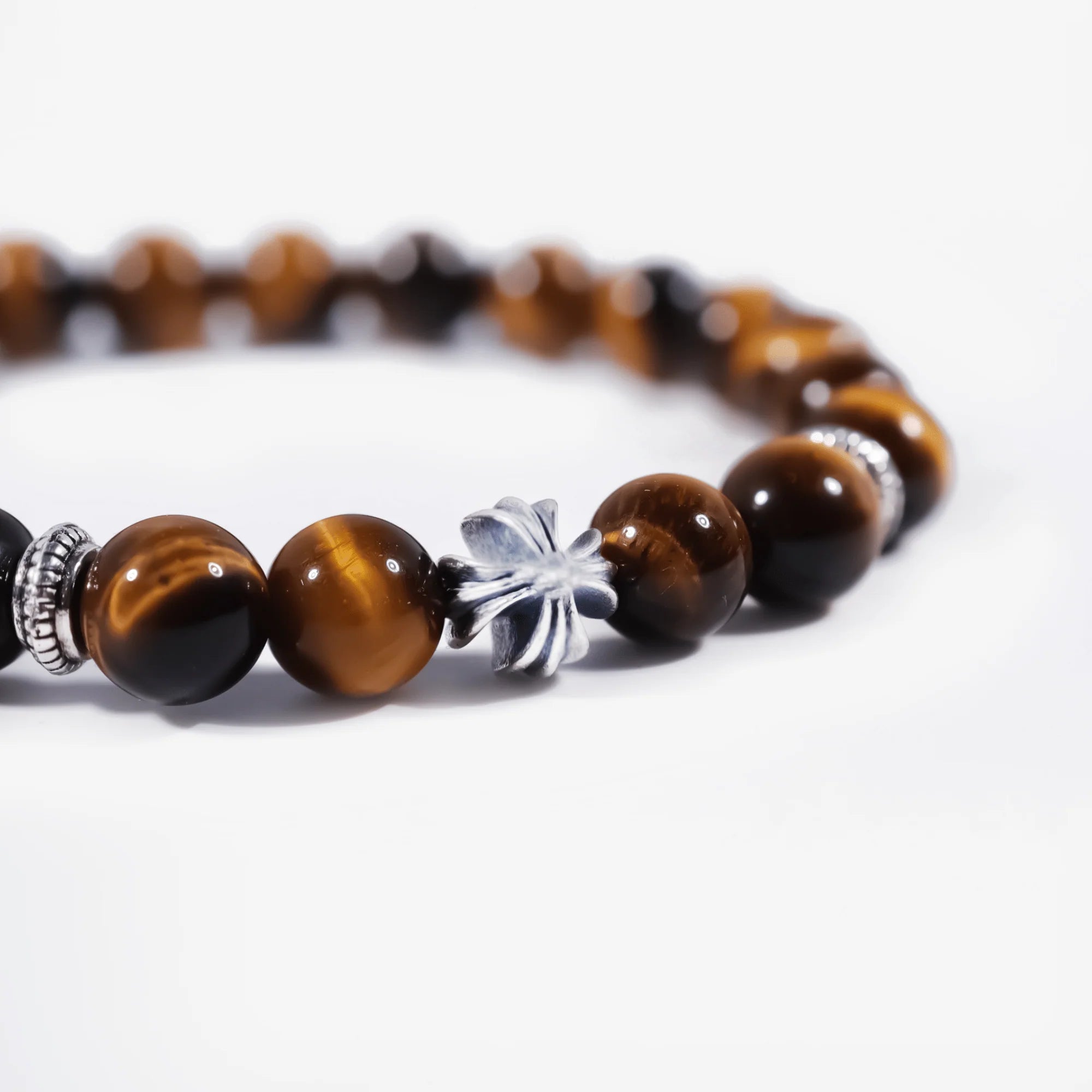 Cropped left-side half view of the natural tiger's eye cross bracelet on a pure white background.