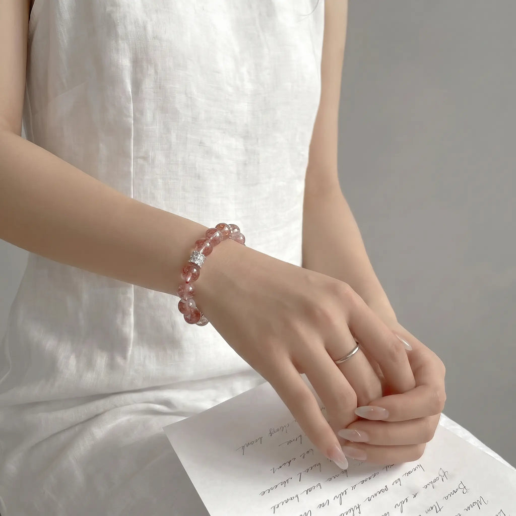 Right-side view of an elegant seated lady resting hands over her thighs to showcase the premium quartz crystal bracelet.