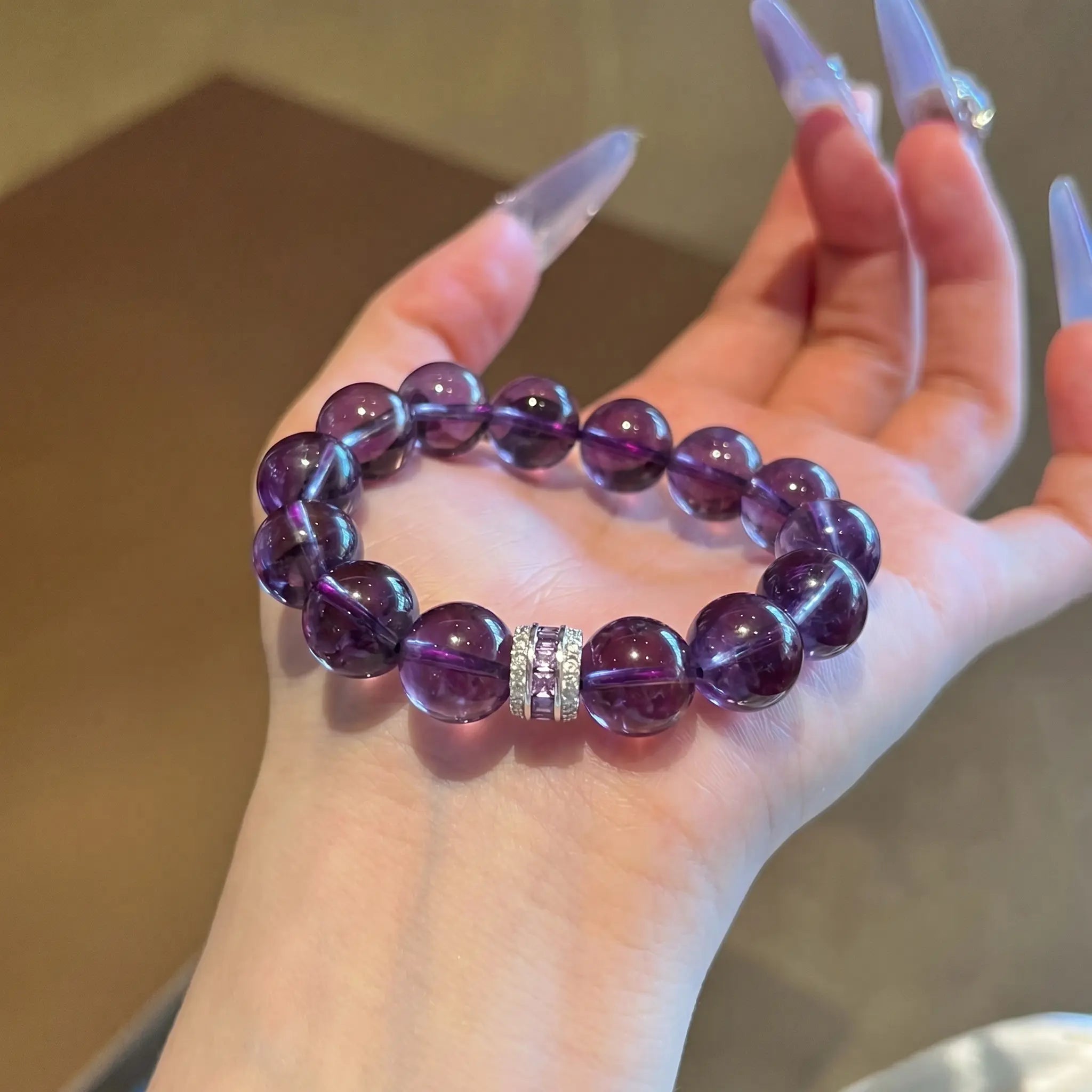 Detailed macro shot of the Eternal Elegant Amethyst Bracelet resting in an open hand with a focused view on the silver rhinestone spacer.