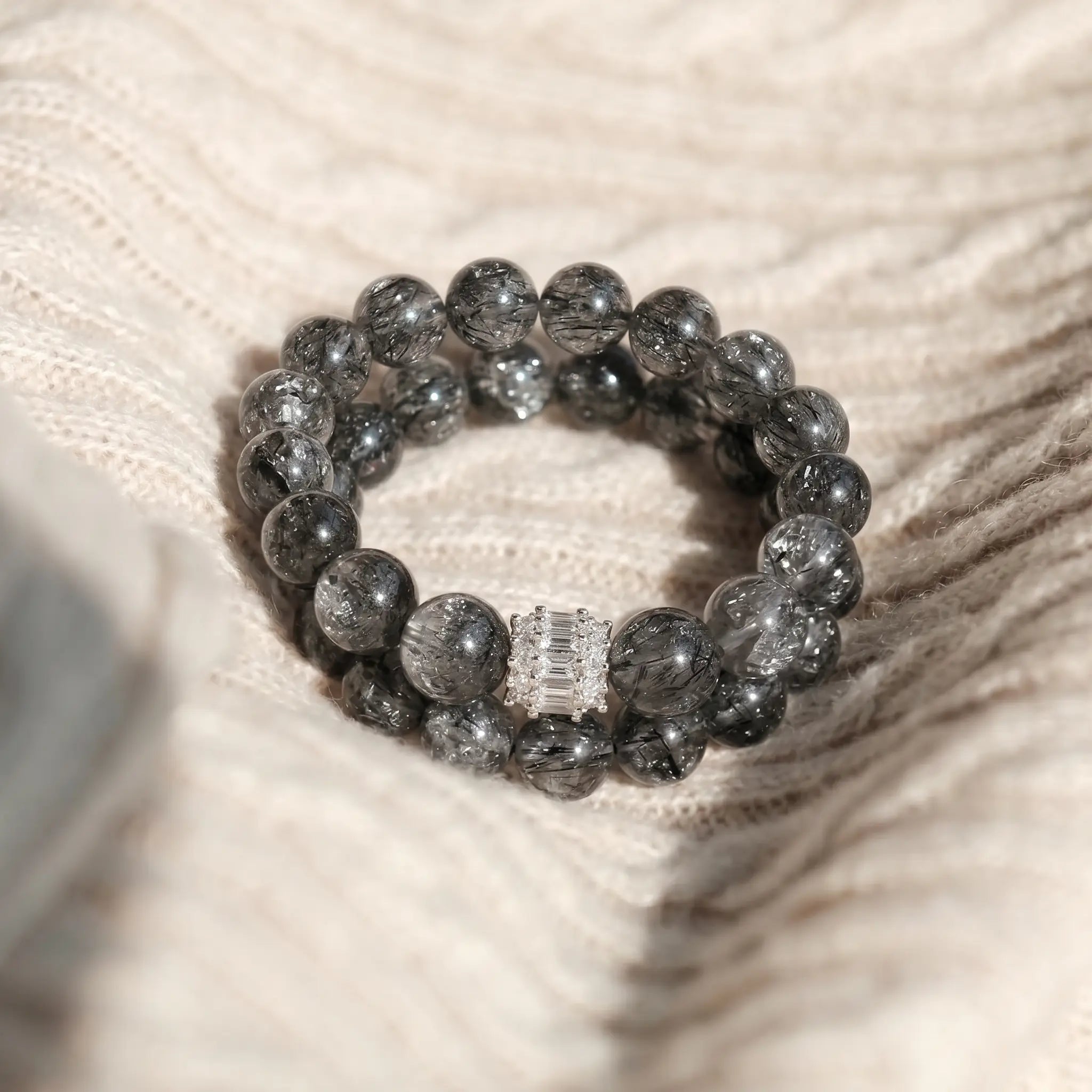 Front close-up view of a woman left arm resting naturally downward showcasing the clear quartz beaded bracelet.