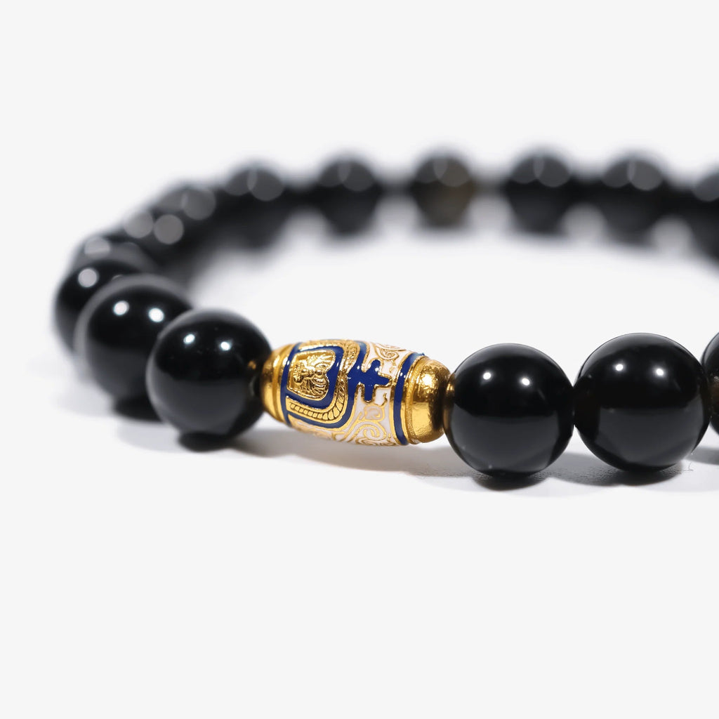 Cropped right-side half-view of the luxury gold-enameled black crystal bracelet on a pure white background.