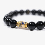 Cropped right-side half-view of the luxury gold-enameled black crystal bracelet on a pure white background.