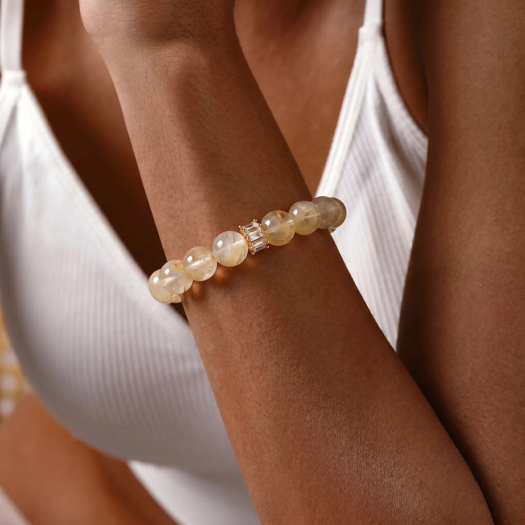 Extreme close-up view focusing on a female wrist adorned with the healing golden hematoid quartz beaded bracelet.