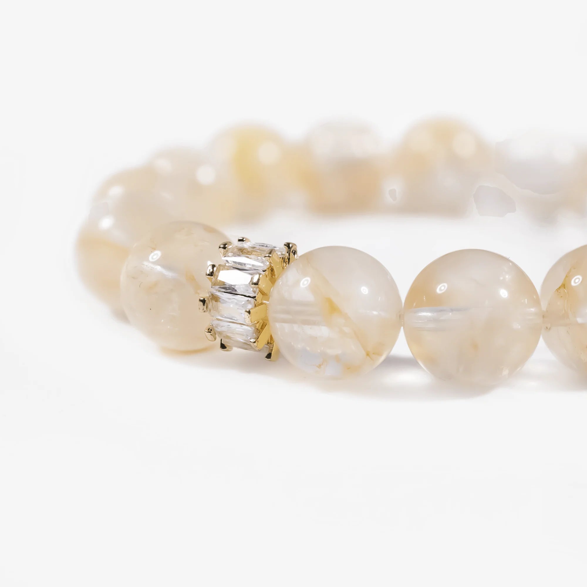 Cropped right-side half-view of the radiant golden hematoid quartz gemstone bracelet on a pure white background.