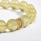 Left-side cropped half-view of the radiant yellow lemon quartz gemstone bracelet on a pure white background.