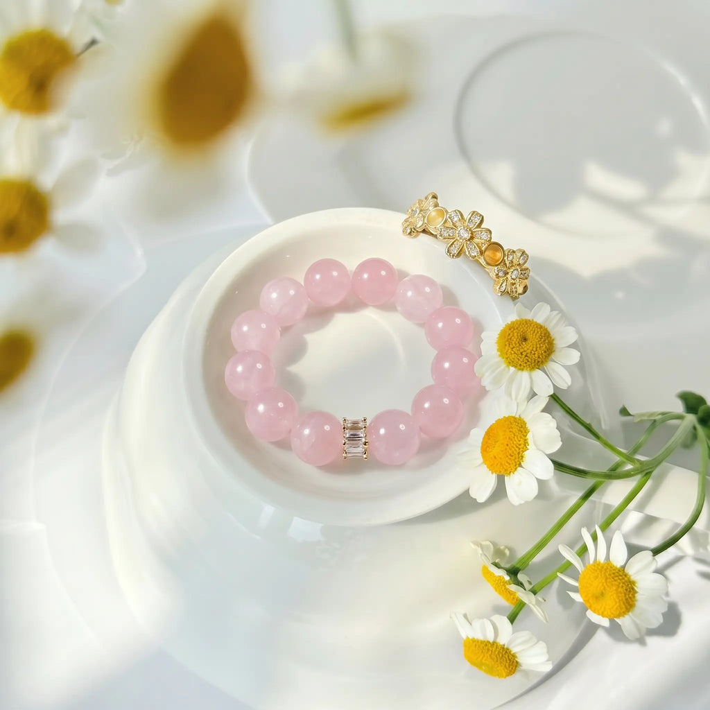 Top-down high angle shot showcasing the fine details of the rose quartz bracelet resting over matching porcelain tableware.