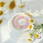 Top-down high angle shot showcasing the fine details of the rose quartz bracelet resting over matching porcelain tableware.