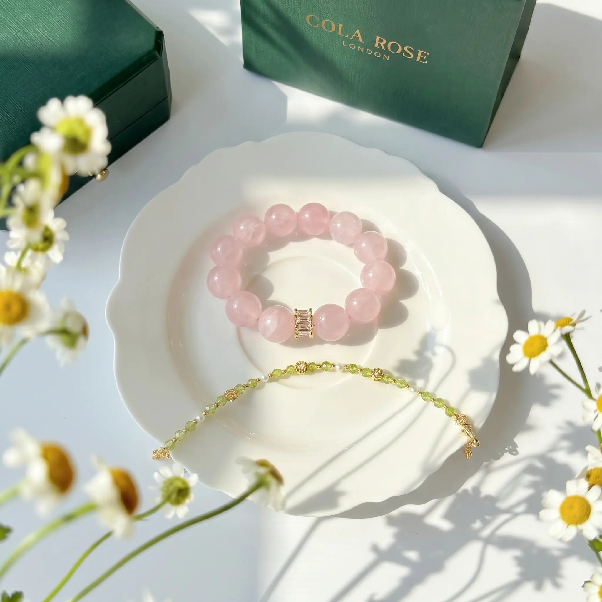 A premium pink quartz energy gemstone bracelet displayed flat on a luxury ceramic porcelain plate.