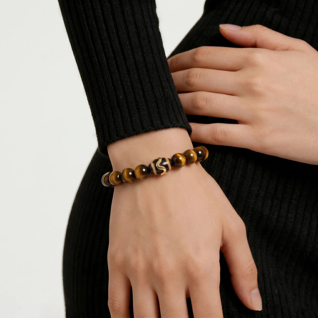 Diagonal close-up from lower-left to upper-right showing a woman wrist styled with a Tibetan dzi bead bracelet.