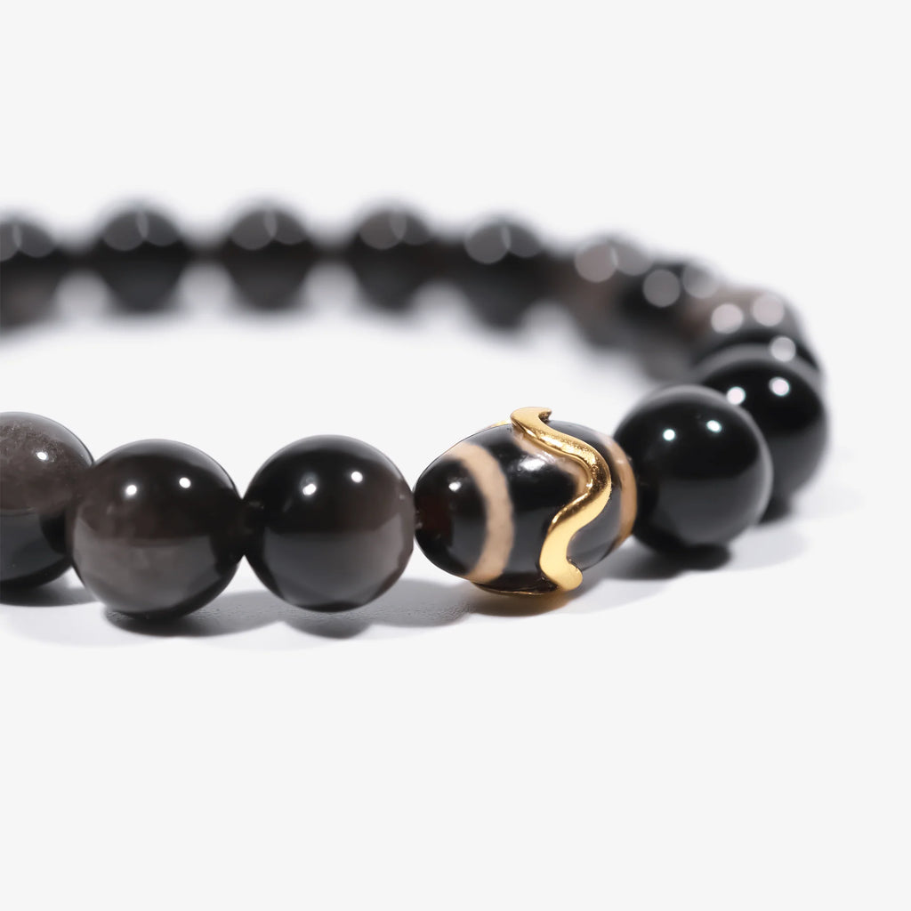 Left-side cropped half-view of the protective black obsidian gemstone bracelet on a pure white background.