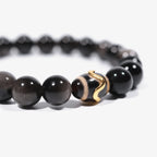 Left-side cropped half-view of the protective black obsidian gemstone bracelet on a pure white background.