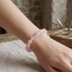 Diagonal perspective from top-left to bottom-right showcasing the detailed view of a pink crystal bracelet on a lady hand.
