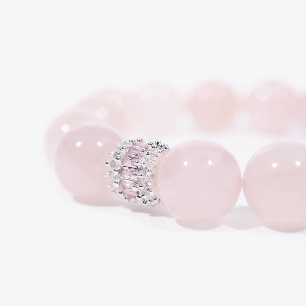 Cropped right-side half-view of the luxury pink rose quartz crystal bracelet on a pure white background.