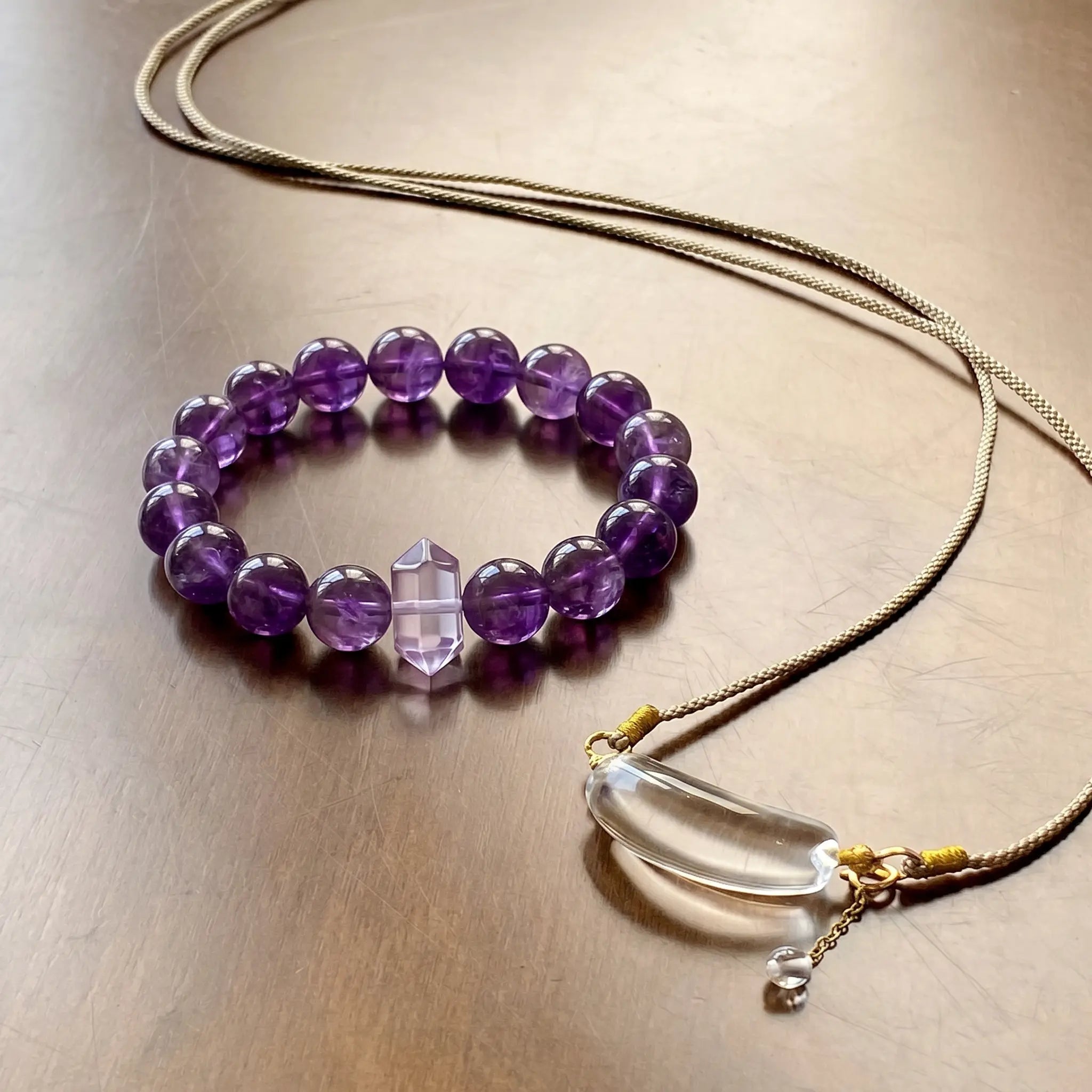 A high-end royal purple amethyst gemstone bracelet resting flat and elegantly over a clean desktop surface.