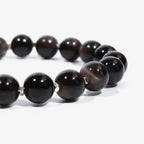 Cropped left side half-view of the protective black obsidian crystal bracelet on a clean white background.