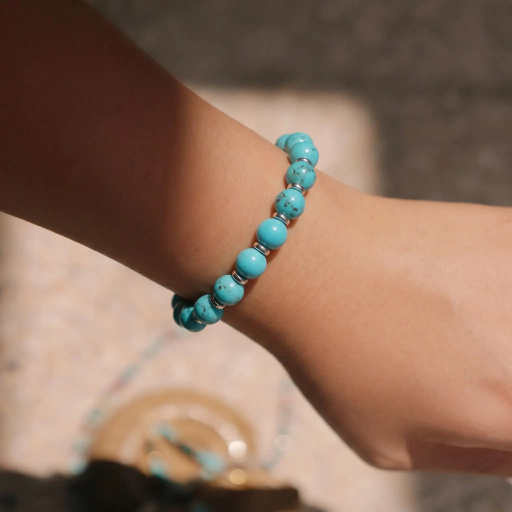 Extreme macro shot focusing on the natural texture of a blue mineral crystal wrist bracelet.