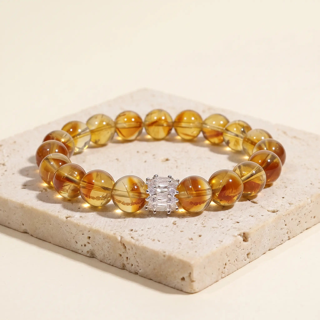 Solar Radiance Citrine Bracelet displayed elegantly on top of a rustic beige travertine stone display plate.