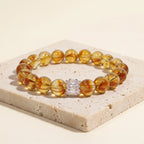 Solar Radiance Citrine Bracelet displayed elegantly on top of a rustic beige travertine stone display plate.