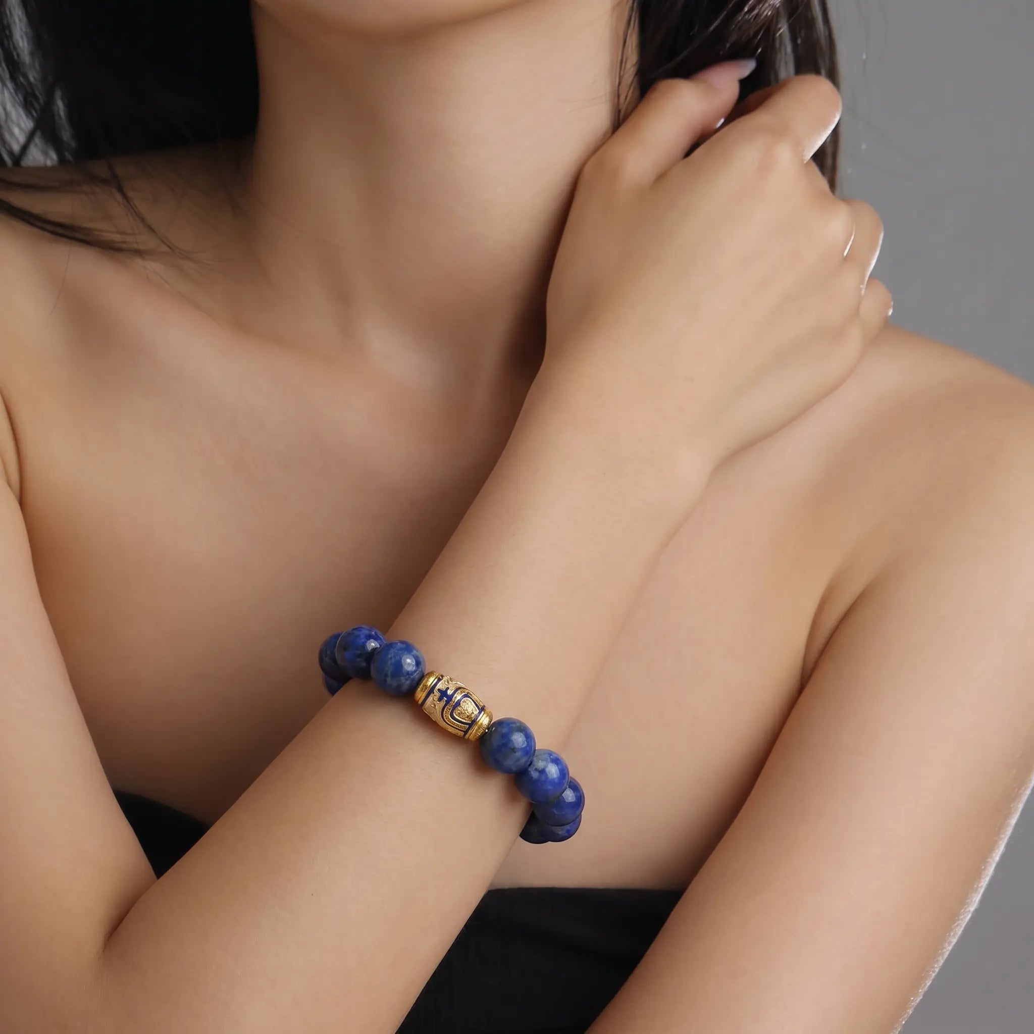 Front view portrait up to the chin showing a lady right forearm raised vertically wearing the Tranquil Lapis Bracelet.
