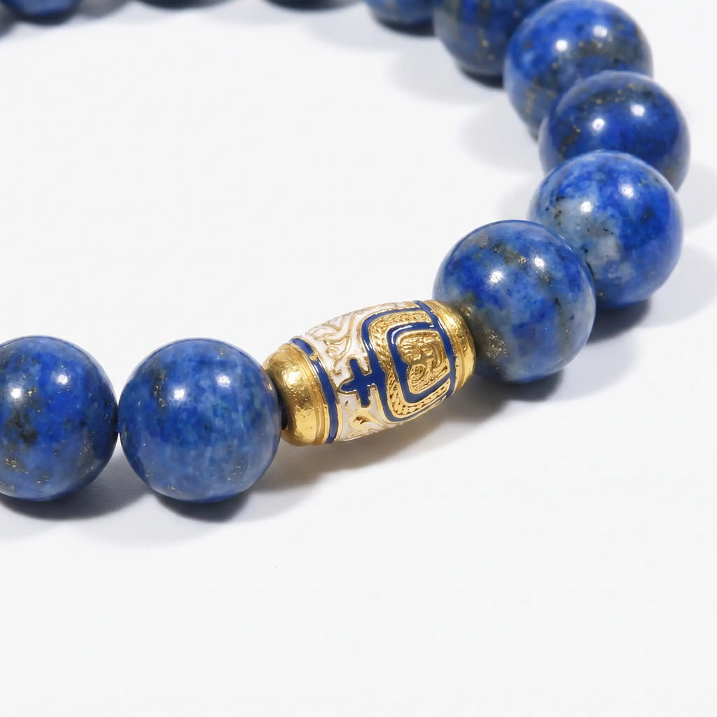 Macro shot of the Tranquil Lapis Bracelet focusing on the natural textures of deep blue lapis lazuli beads and a gold enameled centerpiece.