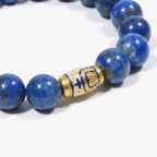 Macro shot of the Tranquil Lapis Bracelet focusing on the natural textures of deep blue lapis lazuli beads and a gold enameled centerpiece.