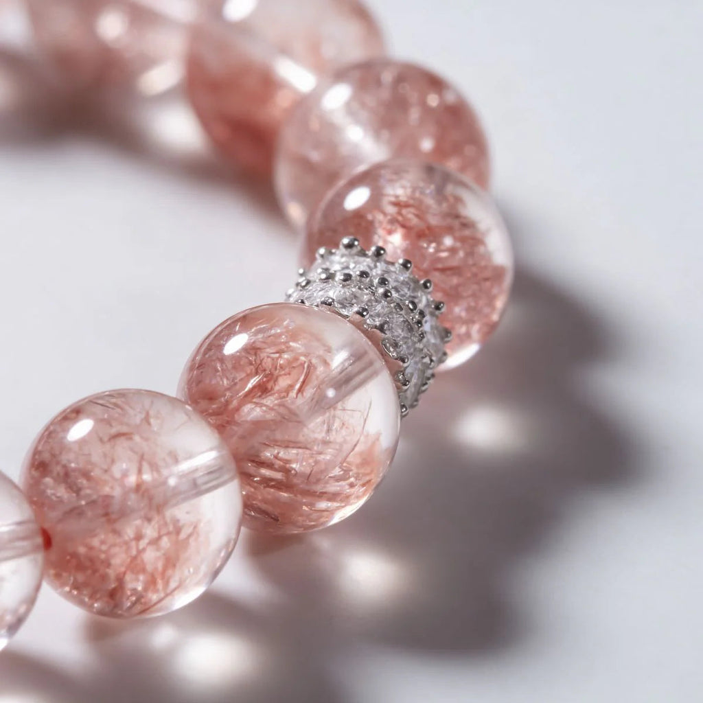 Cropped left-side half-view of the radiant pink strawberry quartz crystal bracelet on a pure white background.