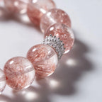 Cropped left-side half-view of the radiant pink strawberry quartz crystal bracelet on a pure white background.