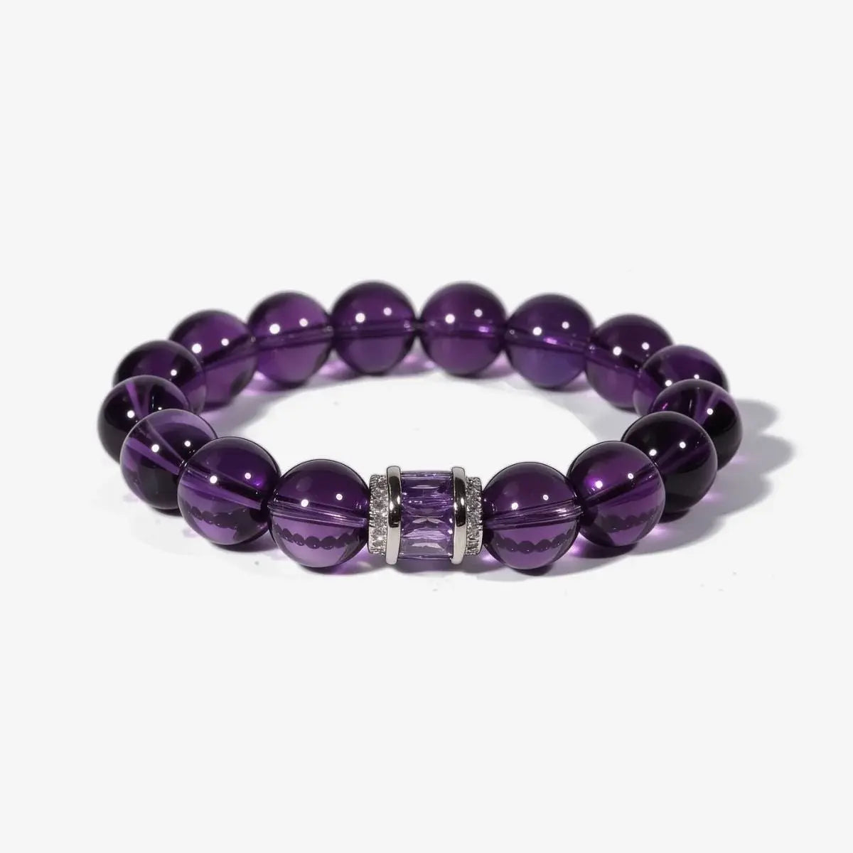 Studio product shot of the graceful amethyst poise bracelet crystal showcasing deep purple gemstone beads and a silver accented centerpiece over white.