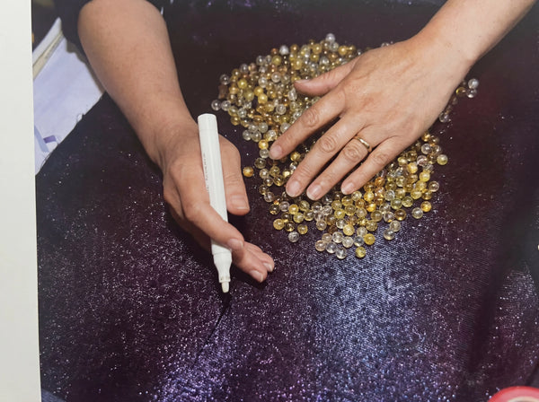 Boring clean holes through natural mineral crystal spheres to create premium beads for handmade bracelets.