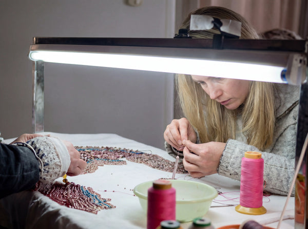 Stringing natural gemstone beads onto a flexible cord during the handmade bracelet assembly process.