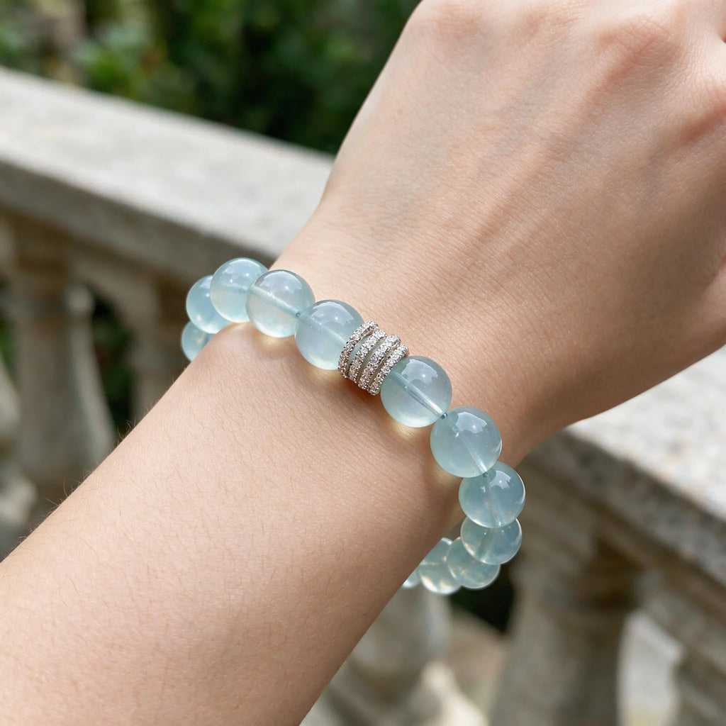 Front portrait shot to the chin showcasing a woman right elbow on a desktop with her raised forearm displaying the jewelry.