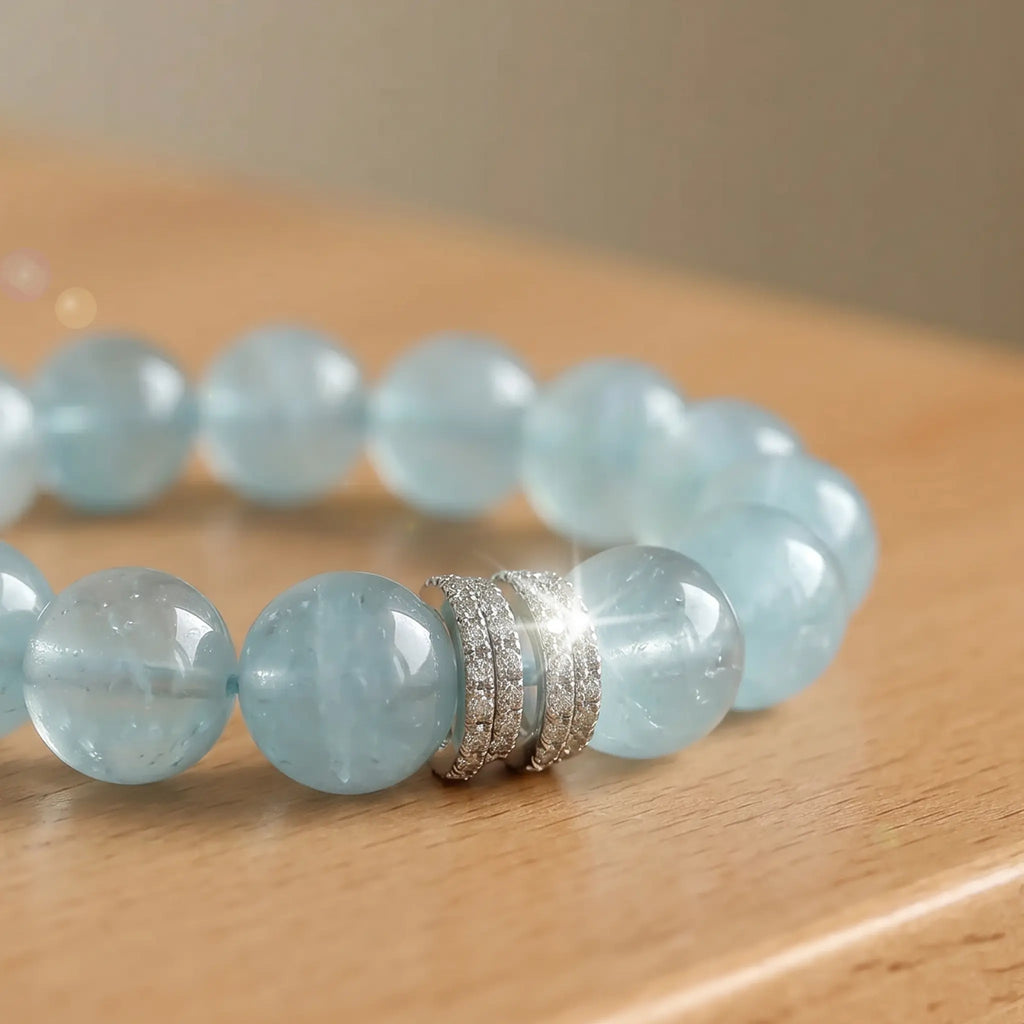 Cropped left-side half view of the ocean blue aquamarine crystal bracelet on a rustic wooden table surface.